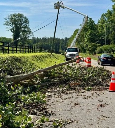 Bucket truck clearing storm damage roadside